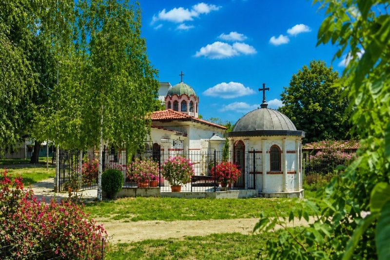 Православен храм и параклис в храм Св. ап. Андрей Първозвани във варна сред зелена градина с цветя.